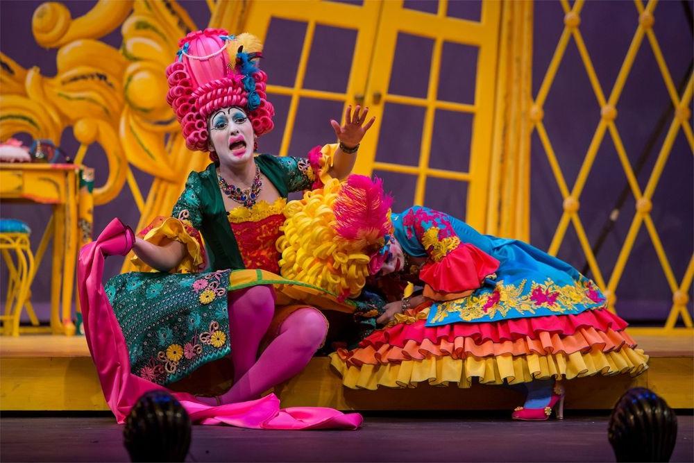 身穿霓虹色戏服、头戴假发的歌剧演员登台表演.