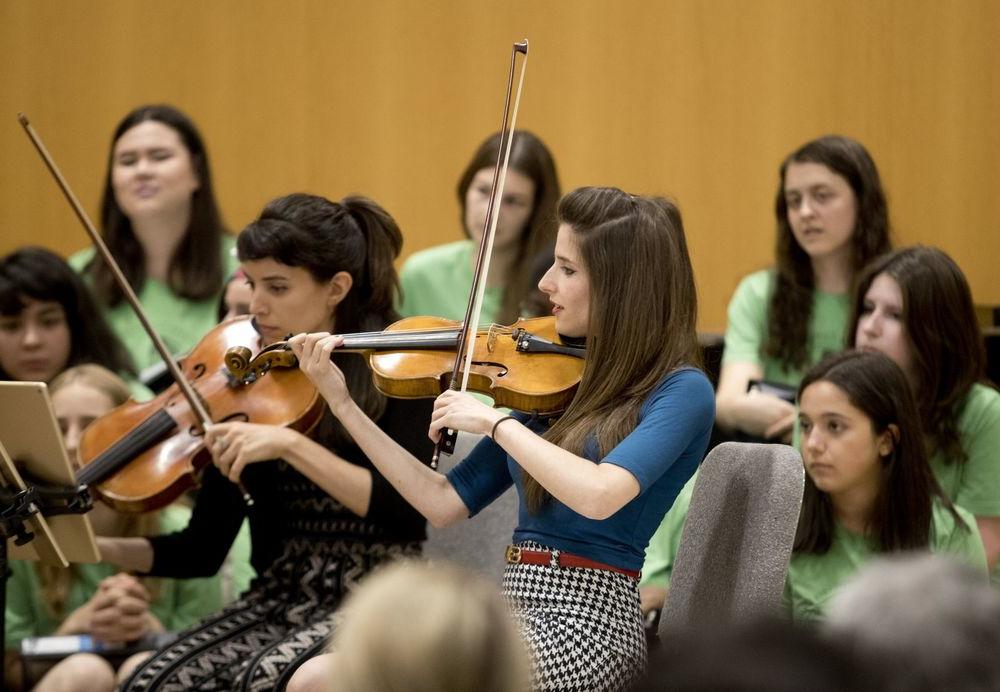 两个女人为学生拉小提琴.